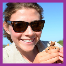 A woman smiling and holding a small animal